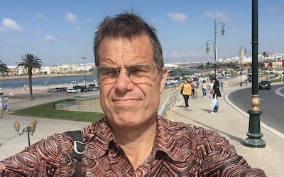 Rabat-Salé, Morocco: Man's selfie with city view featuring palm trees, the Bou Regreg river, and the cityscape of Salé.